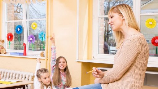 Im Unterricht Klassenzimmer mit Kindern und einer Lehrerin