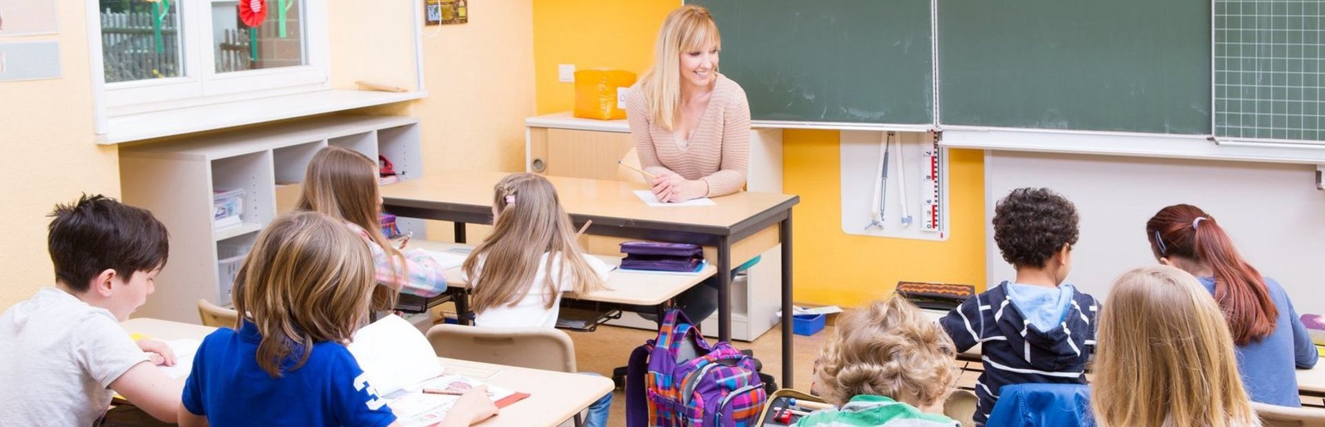 Klassenzimmer mit Kindern und einer Lehrerin