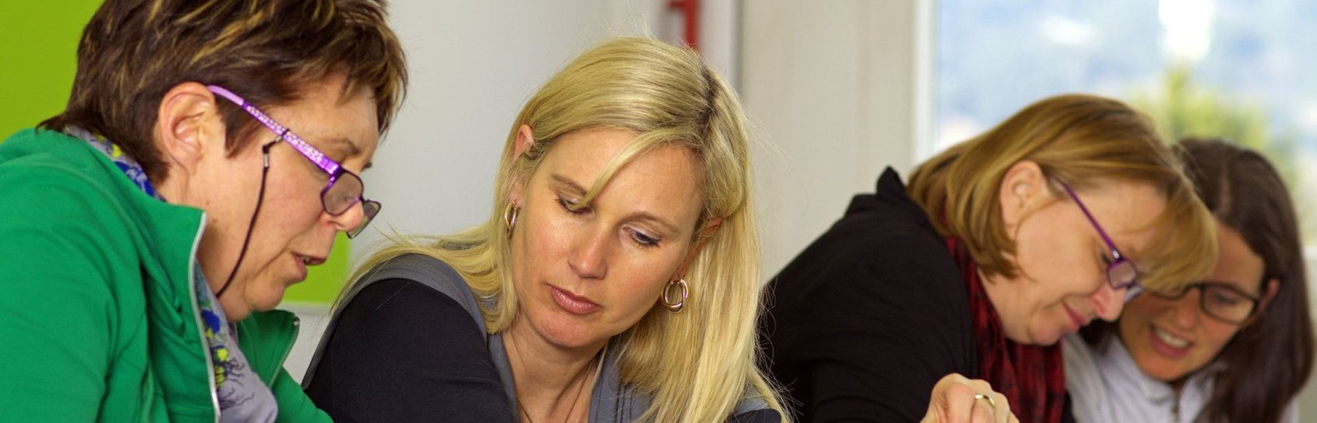 Vier Frauen sitzen zusammen und besprechen etwas