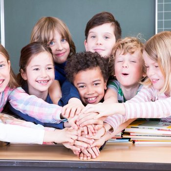 Kinder halten ihre Hände in die Mitte