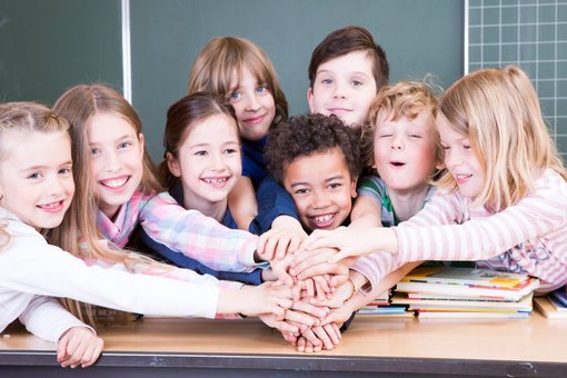 Kinder halten ihre Hände in die Mitte